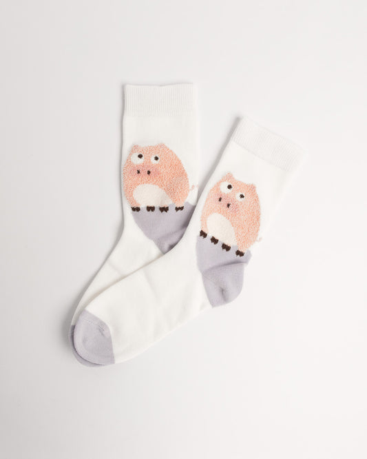 A pair of white crew socks featuring a cute pink and lavender owl graphic on the side, displayed on a clean white background.