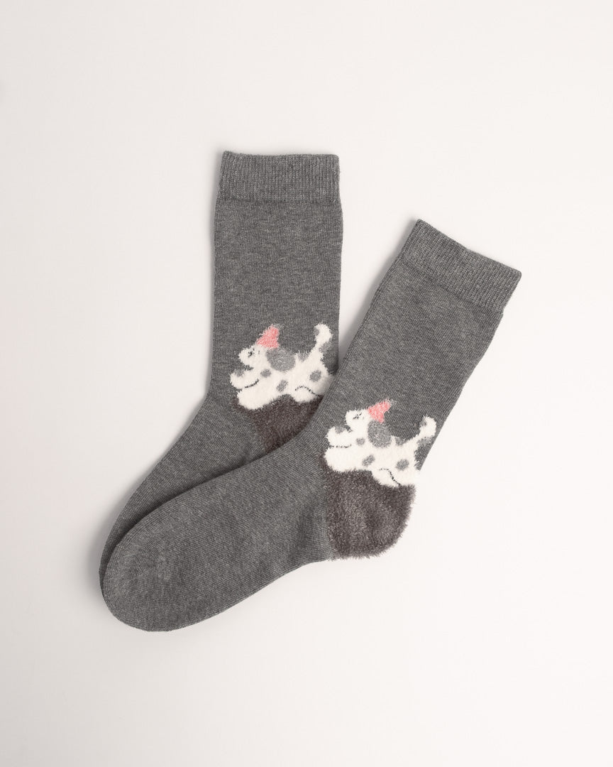 A pair of dark gray crew socks featuring a white and gray spotted dog design with a small pink bow on each sock, displayed on a clean off-white background.