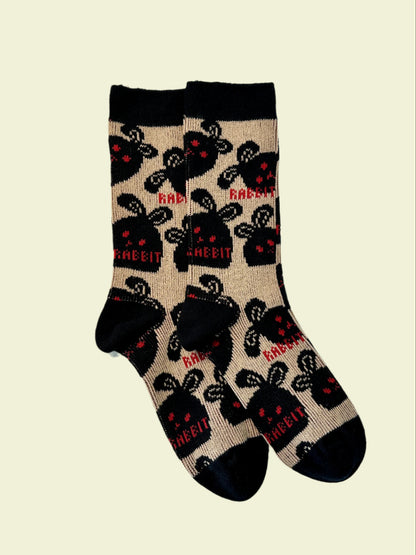 Black cotton crew socks with bold black bunny face pattern and red 'RABBIT' text on beige background – women’s streetwear style