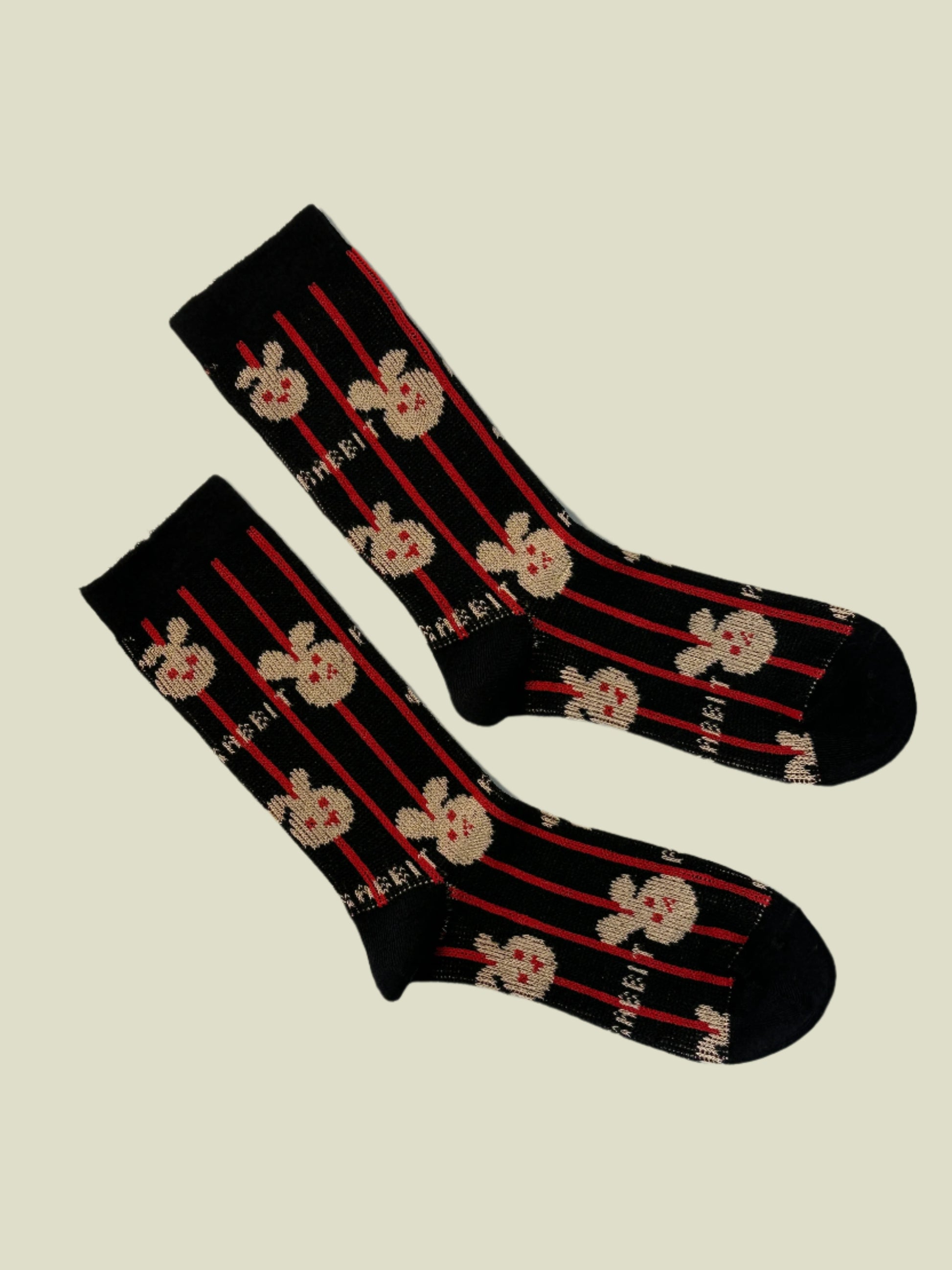 Pair of socks with floral pattern and red stripes on a beige background