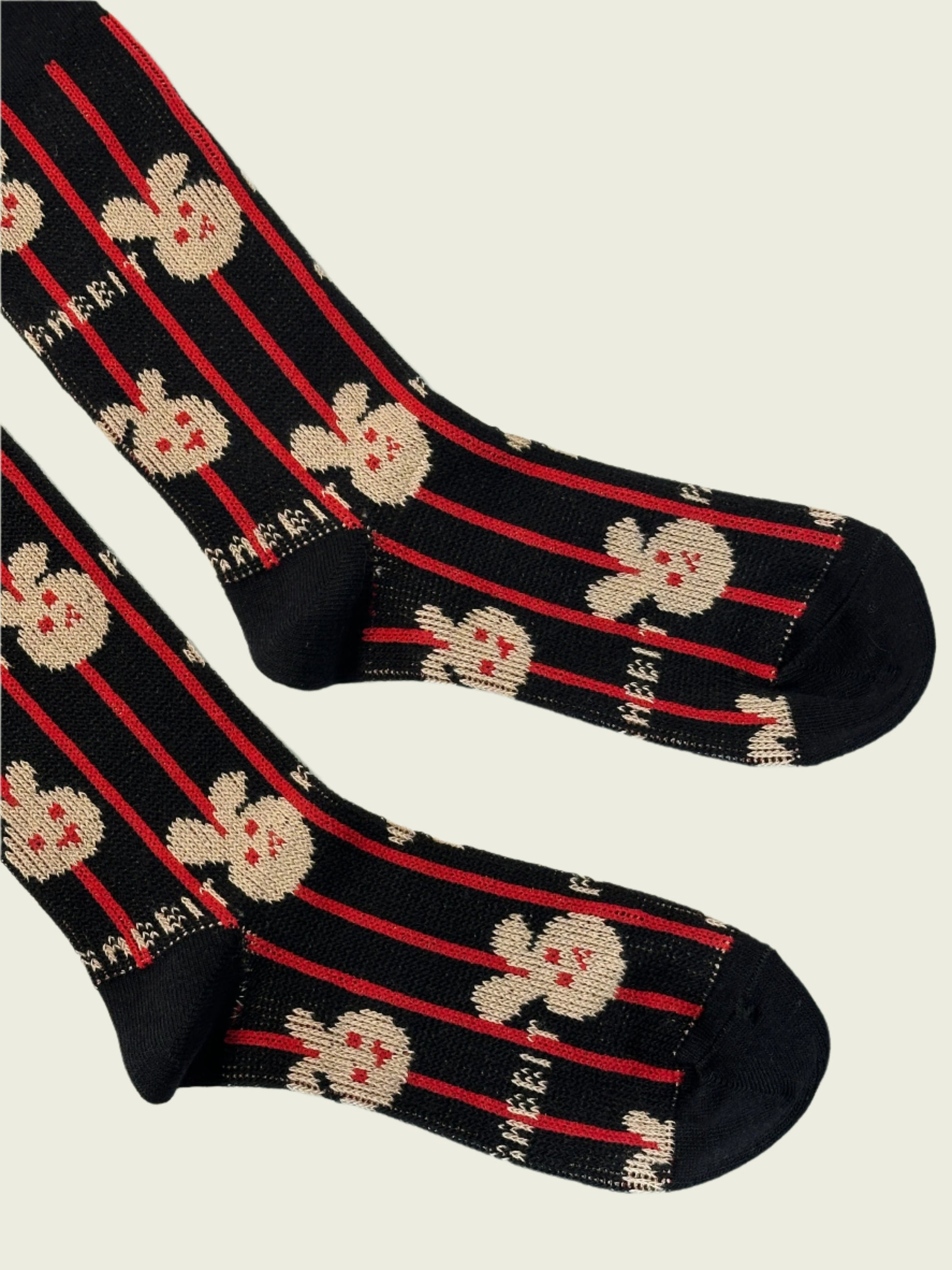 Black socks with red stripes and white skull designs on a light background
