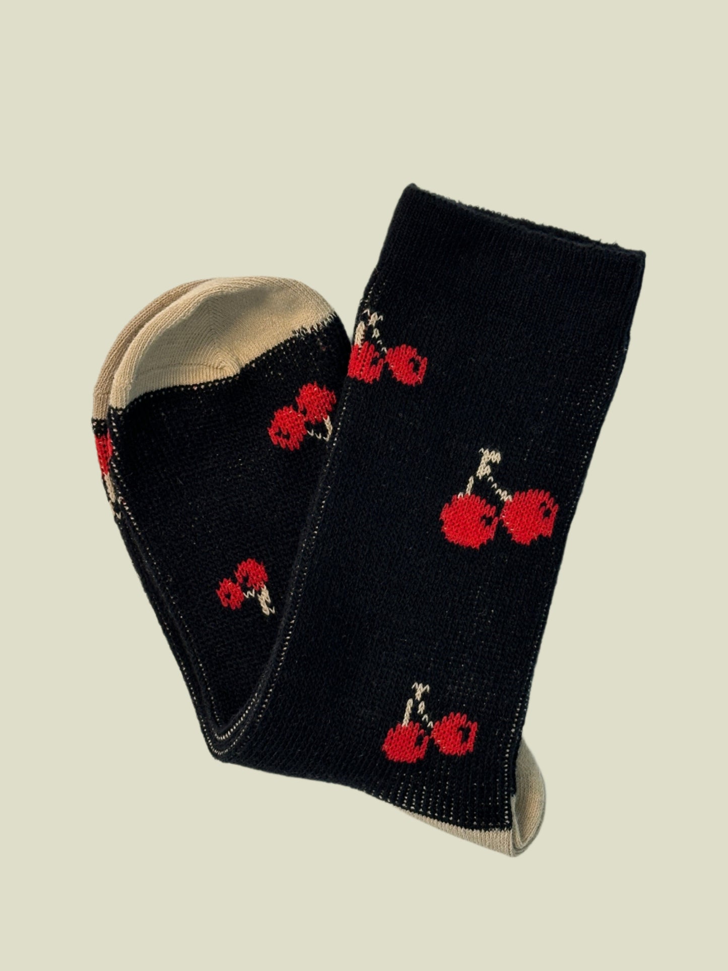 Black socks with red floral patterns on a light gray background