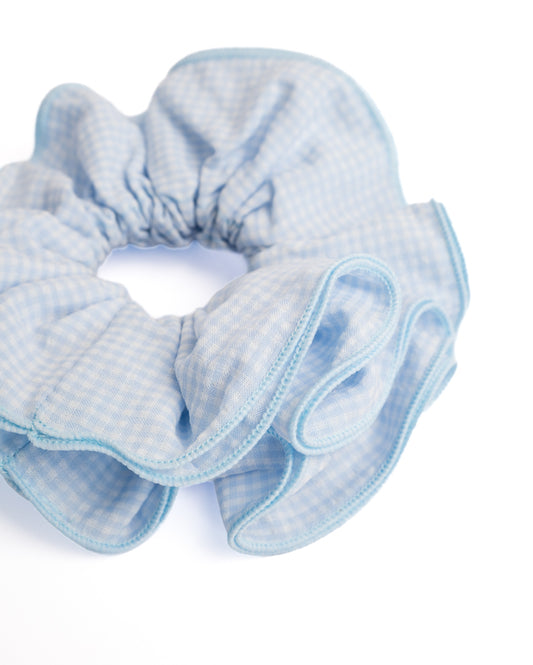 Close-up of light blue gingham cotton scrunchie showing fabric texture and matching blue edge trim details
