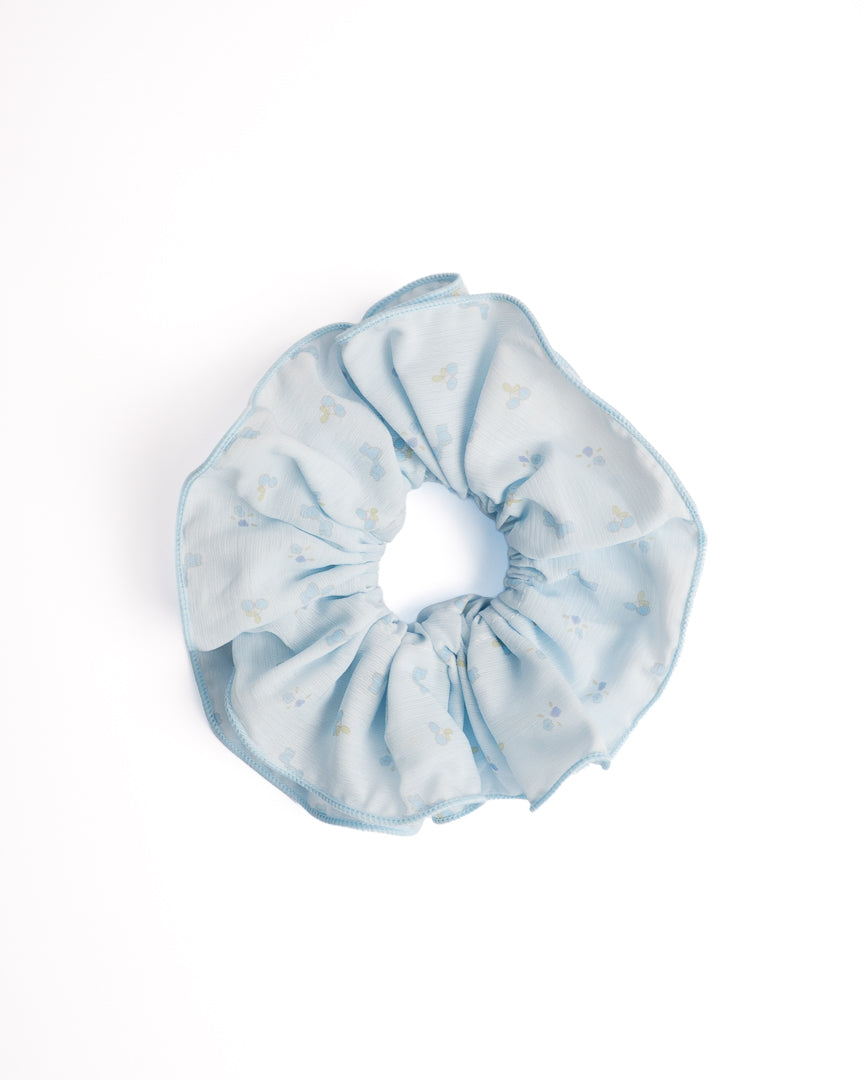 Blue Floral Sheer Hair Scrunchie in light blue featuring little blue flowers on flat lay white background
