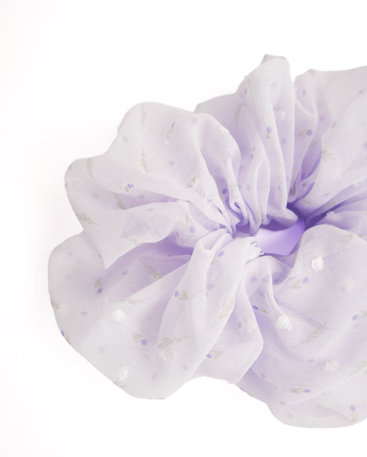 Close-up of lavender Swiss dot organza scrunchie showing textured mesh fabric and floral print details