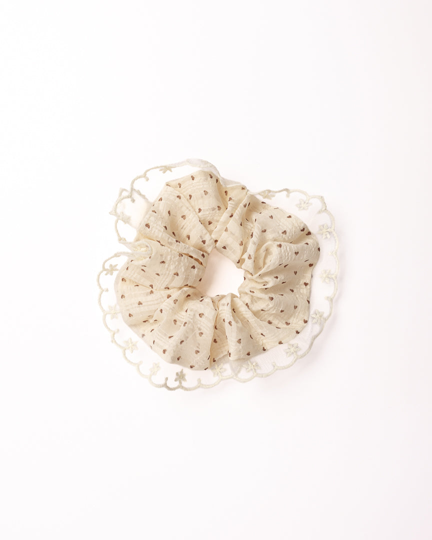 Scalloped Heart Sheer Hair Scrunchie in cream featuring brown heart print and embroidered lace trim on flat lay white background