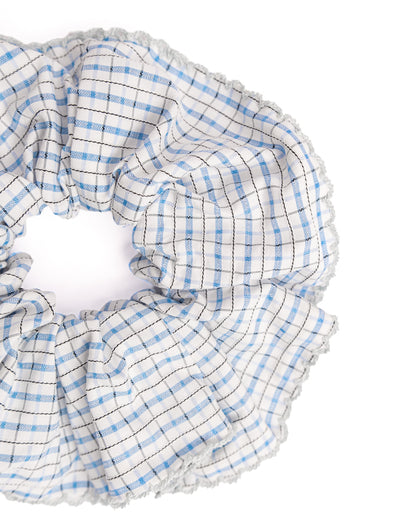 Close-up of blue gingham hair scrunchie showing fabric texture and light blue trim details
