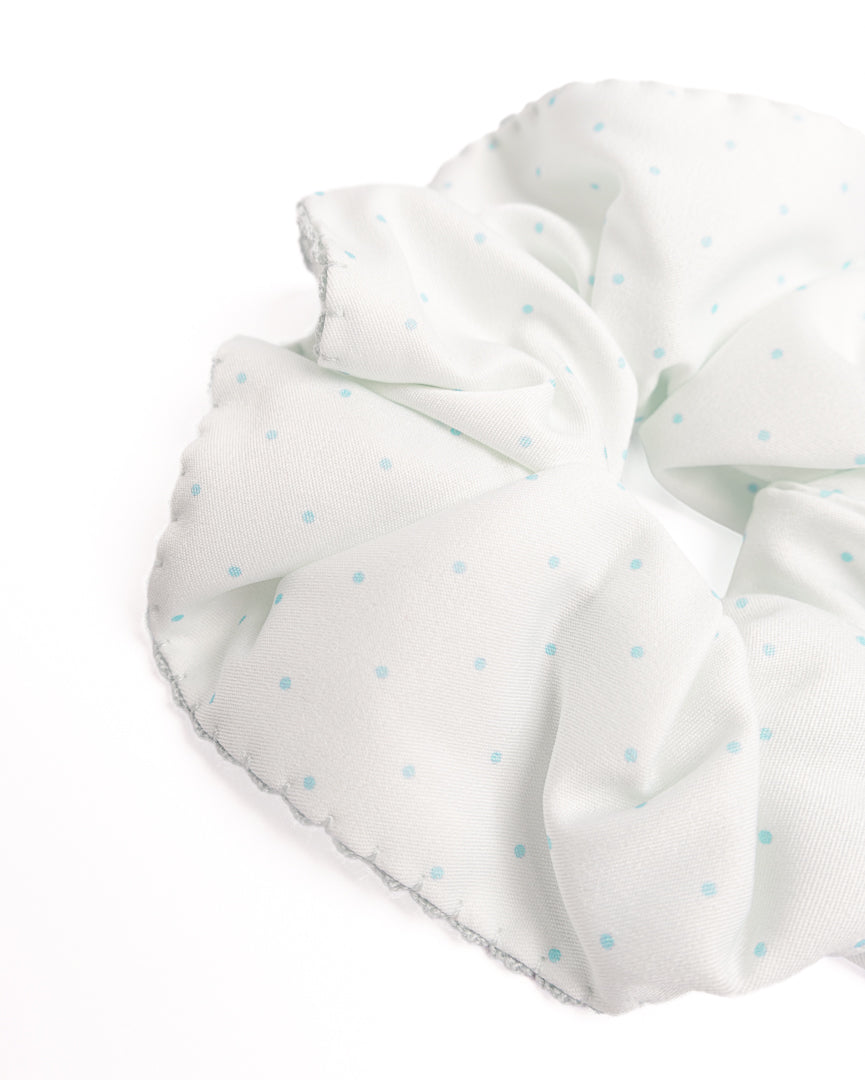 Close-up of mint green polka dot silky hair scrunchie showing smooth fabric texture and scalloped crochet trim details