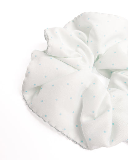 Close-up of mint green polka dot silky hair scrunchie showing smooth fabric texture and scalloped crochet trim details
