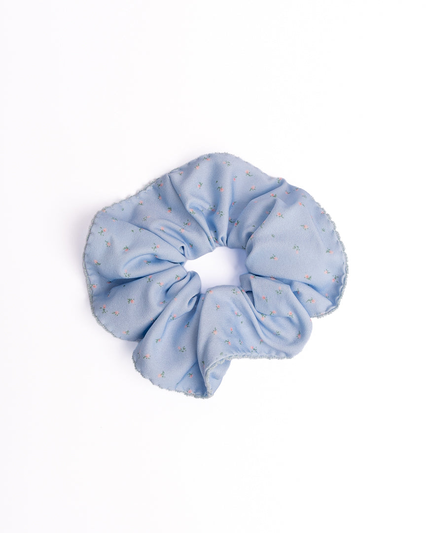 Ditsy Floral Scalloped Silky Hair Scrunchie in light blue featuring mini floral print and scalloped crochet edge on flat lay white background