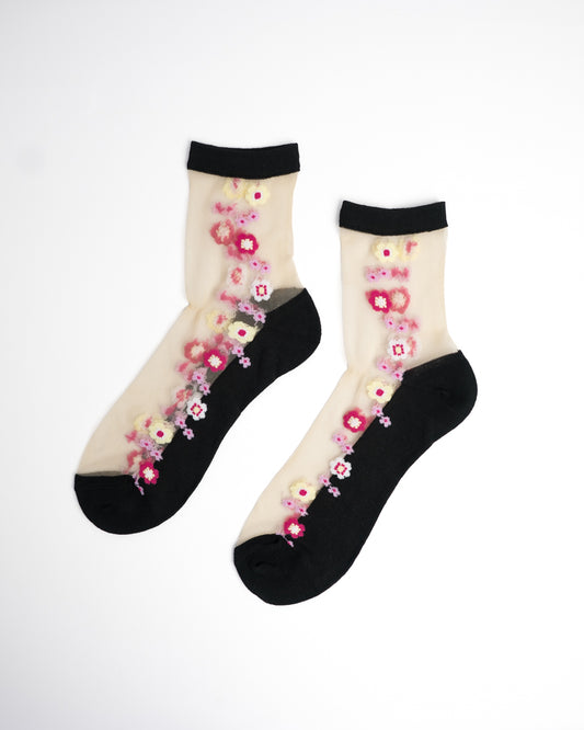 Blossom Pink Sheer Crew Socks in black with pink and yellow floral embroidery on flat lay white background