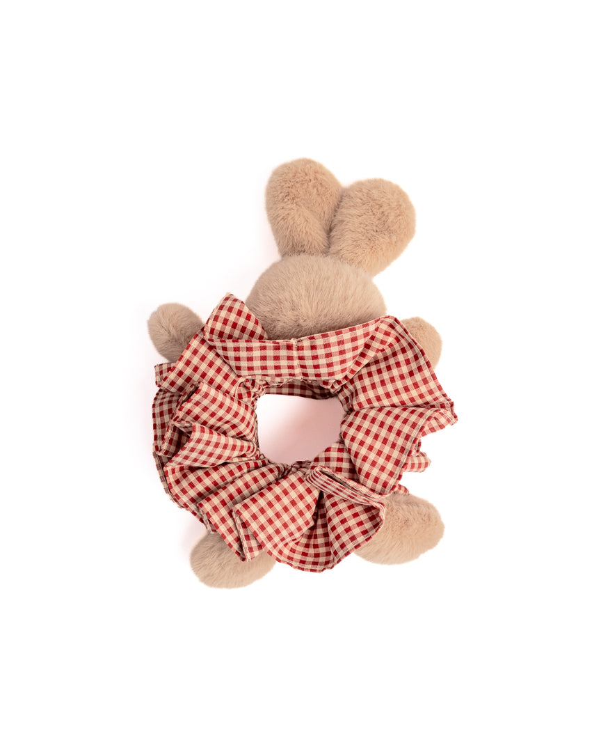 Close-up of plush bunny hair scrunchie showing cute rabbit face and red gingham fabric ruffles