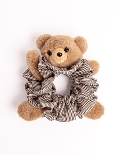 Side view of plush teddy bear hair scrunchie in brown check fabric showcasing soft texture