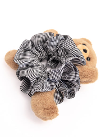 Side view of plush teddy bear hair scrunchie in black and white check fabric showcasing soft texture and voluminous ruffles