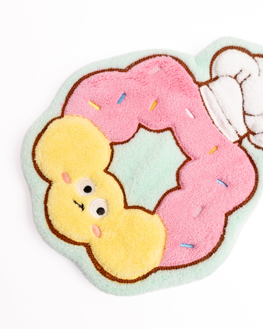 Close-up of pink donut hanging hand towel showing soft coral fleece texture, sprinkle details, and embroidery
