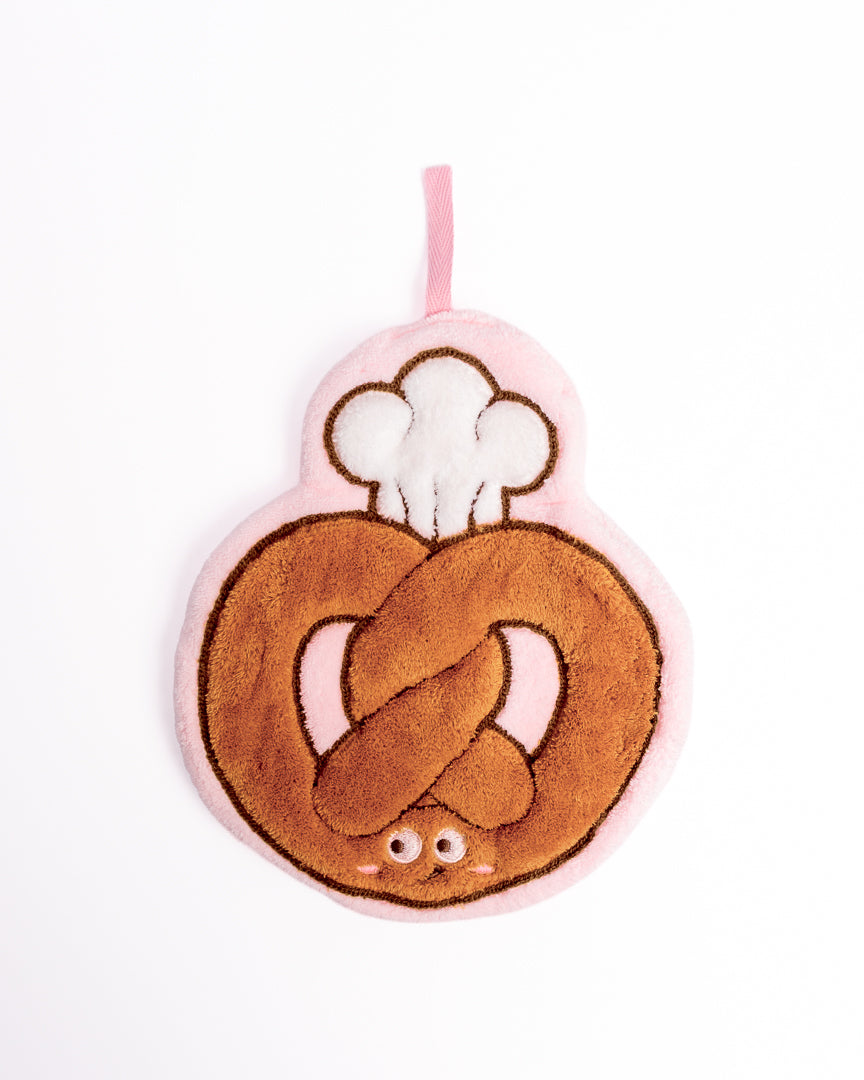 Chef Pretzel Kitchen Hanging Hand Towel featuring brown baked pretzel with chef hat on flat lay white background