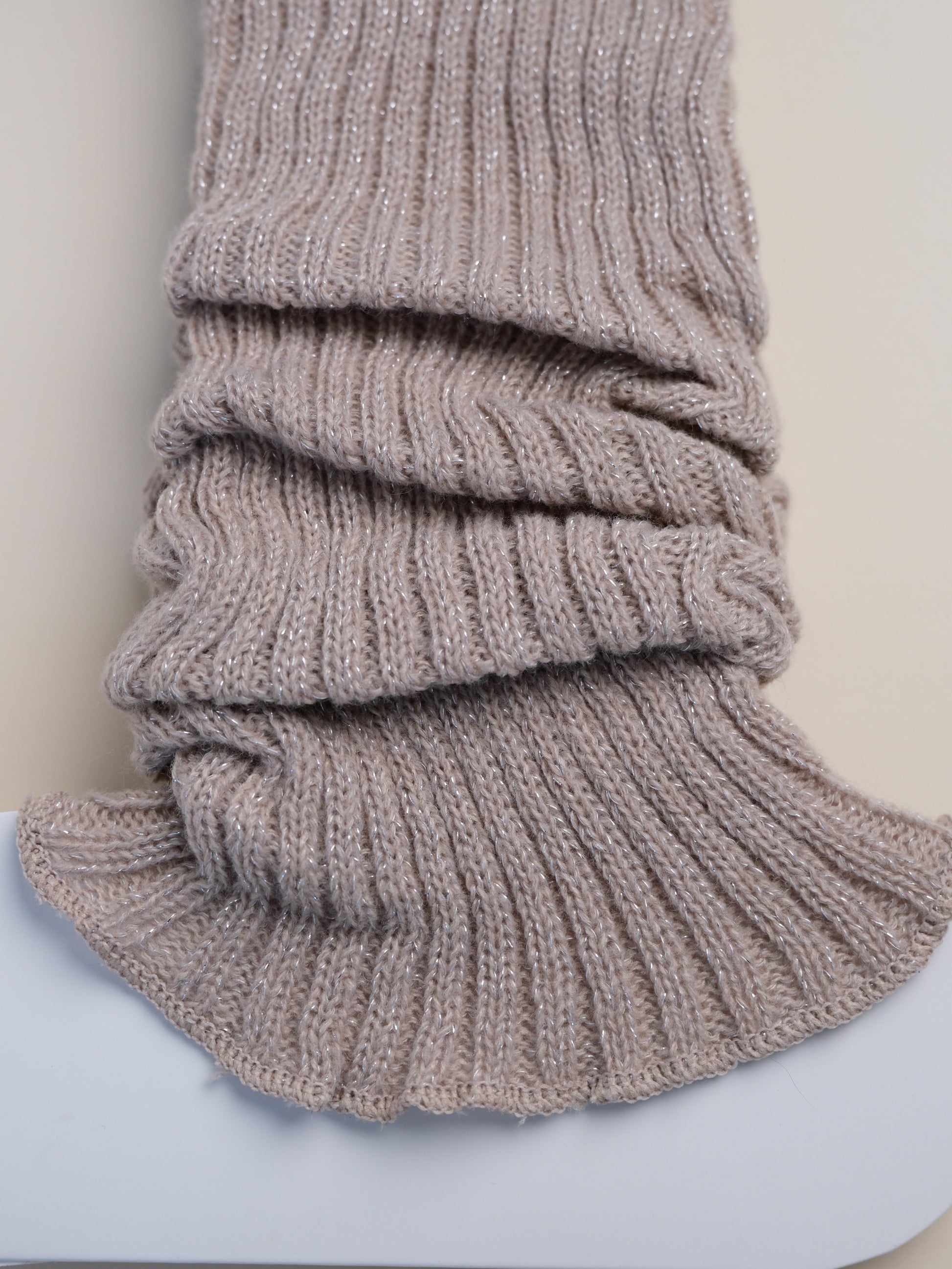 Knitted gray scarf on a light blue surface