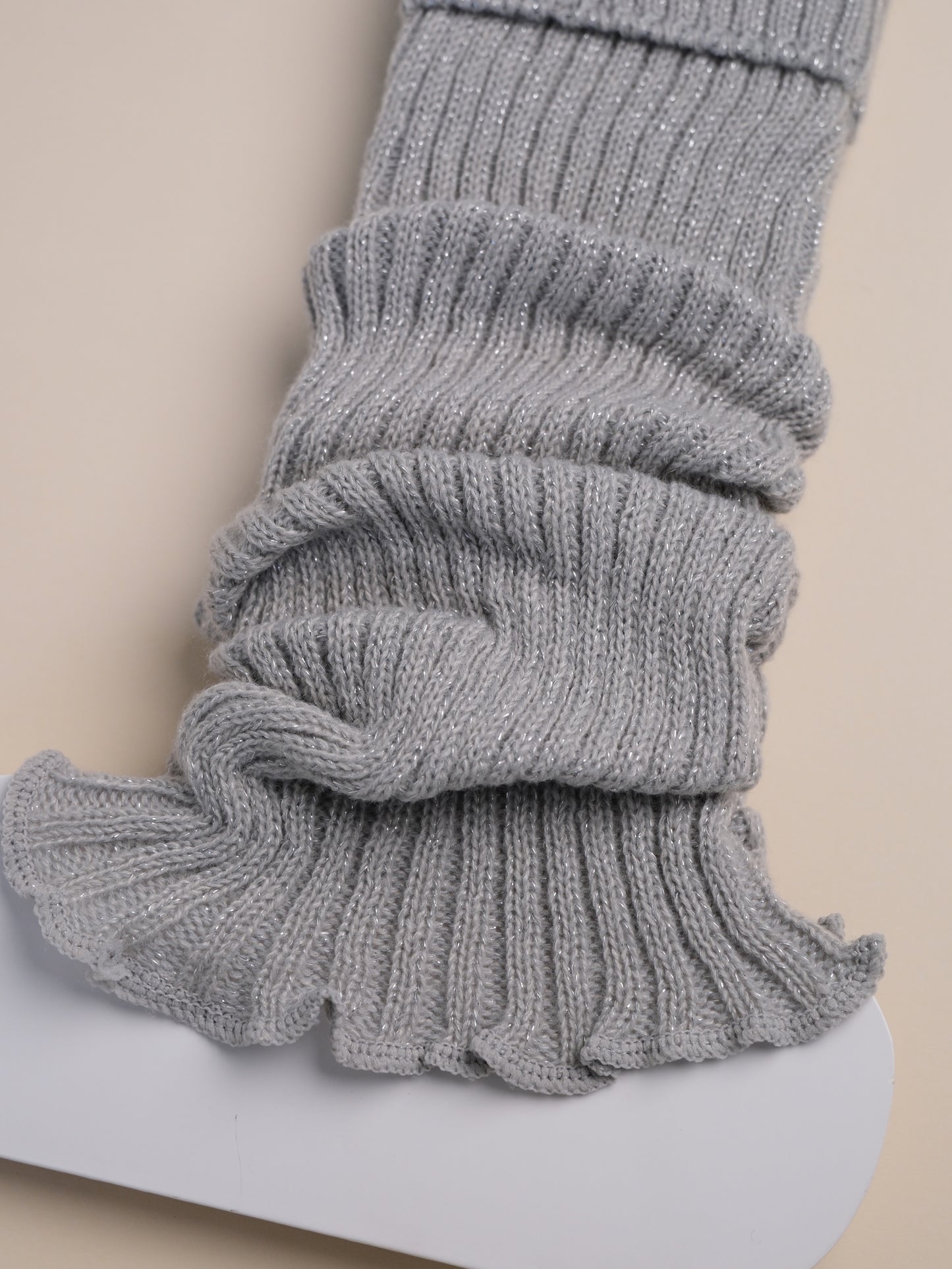 Gray ribbed leg warmers on a white surface