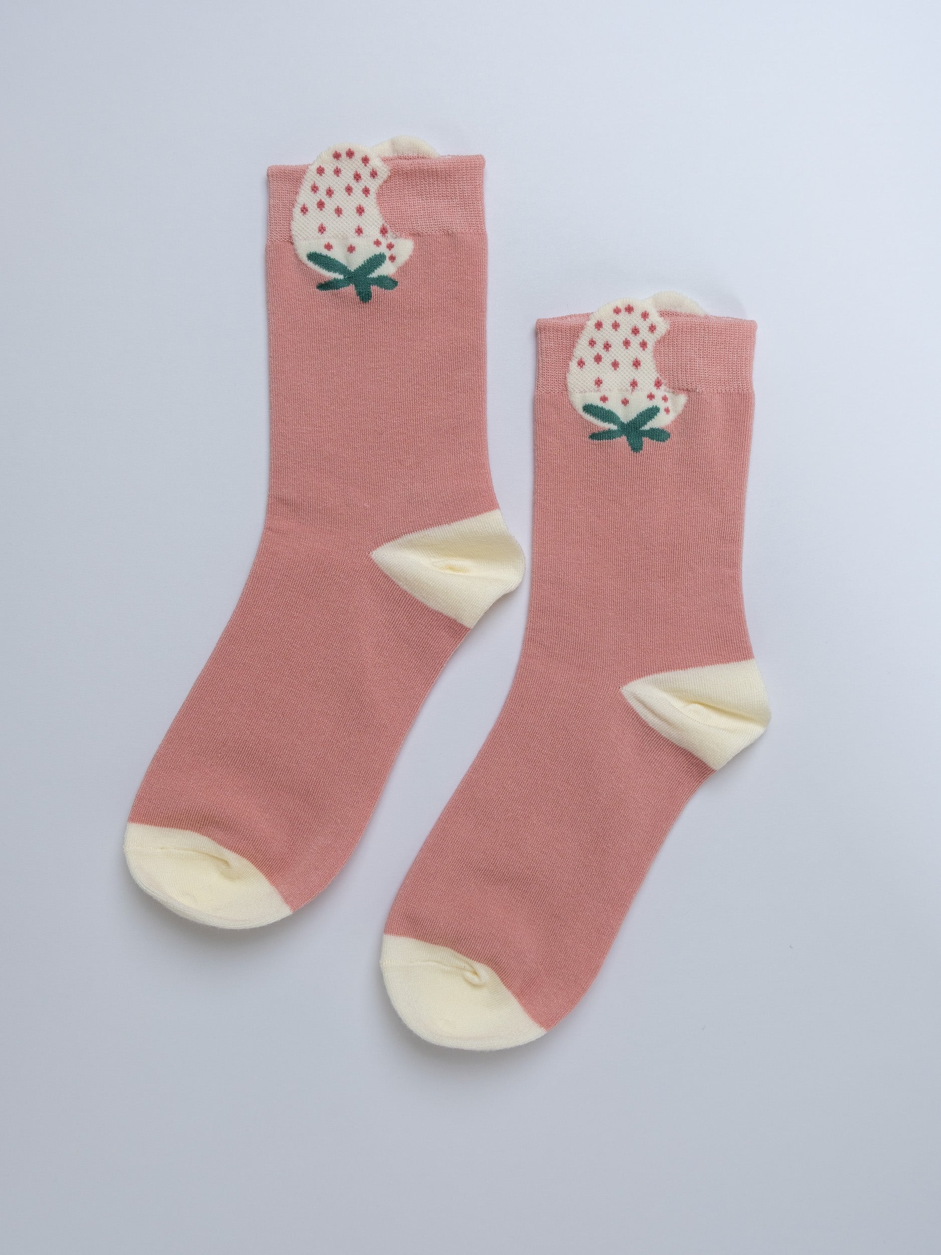 Pink socks with floral design on a light gray background