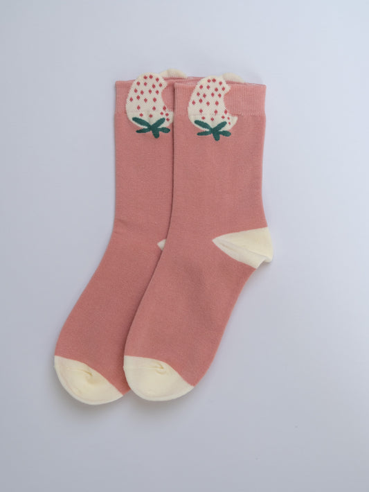 Pink socks with strawberry design on a light gray background