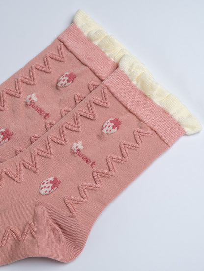 Pink socks with strawberry design and white trim on a light gray background