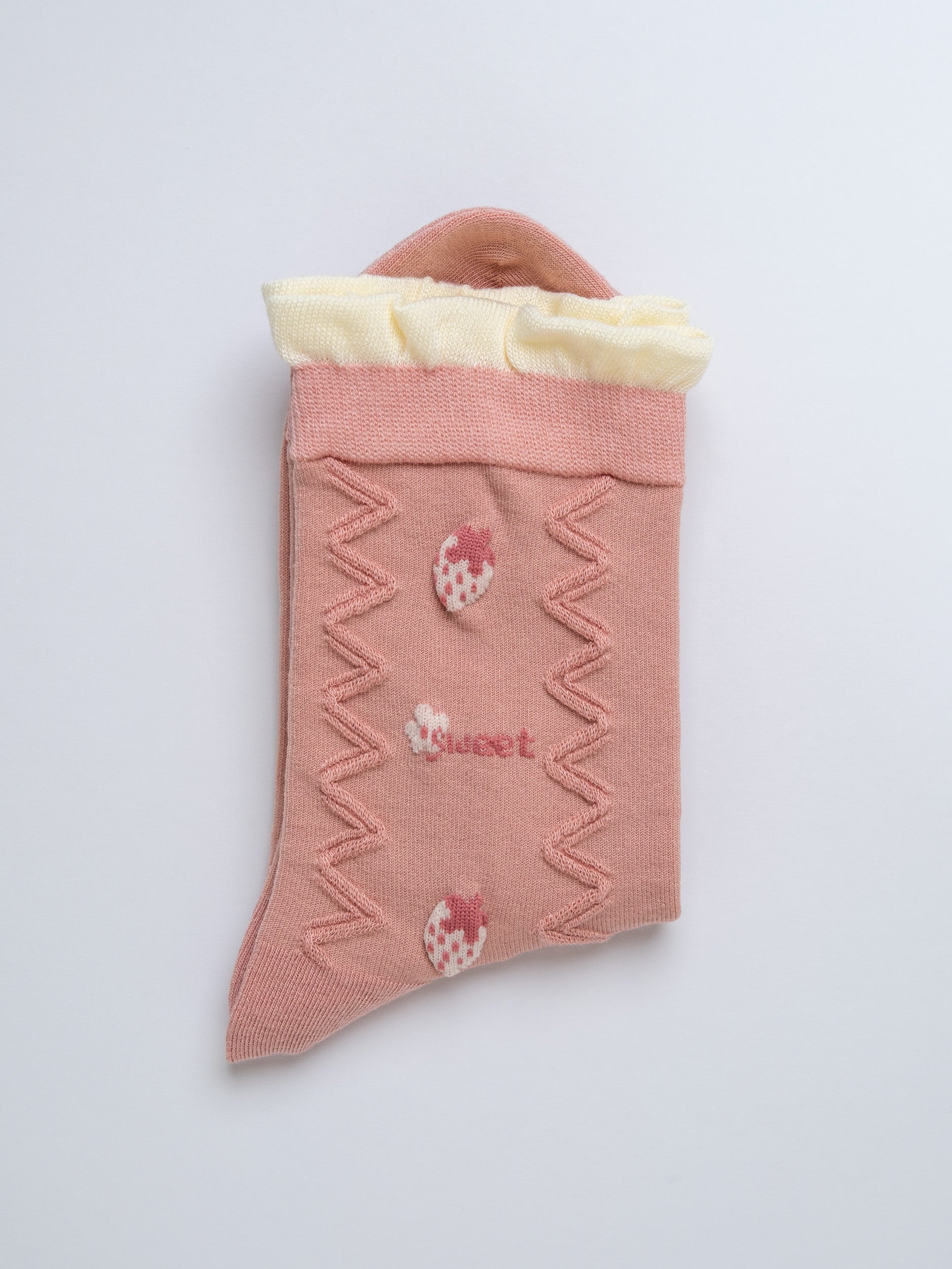 Pink sock with strawberry design and 'sweet' text on a light gray background