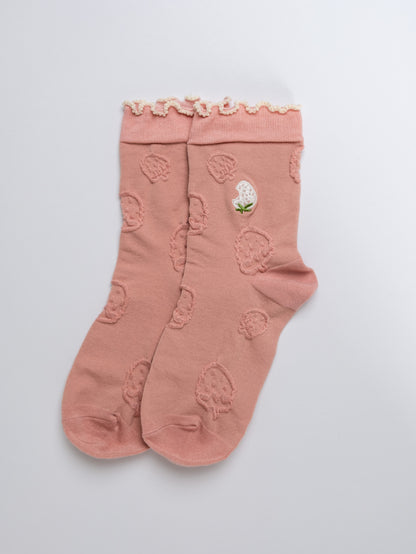 Pink socks with floral design on a light gray background