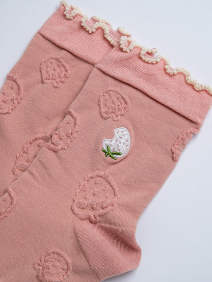 Pink leg warmers with strawberry pattern on a white background
