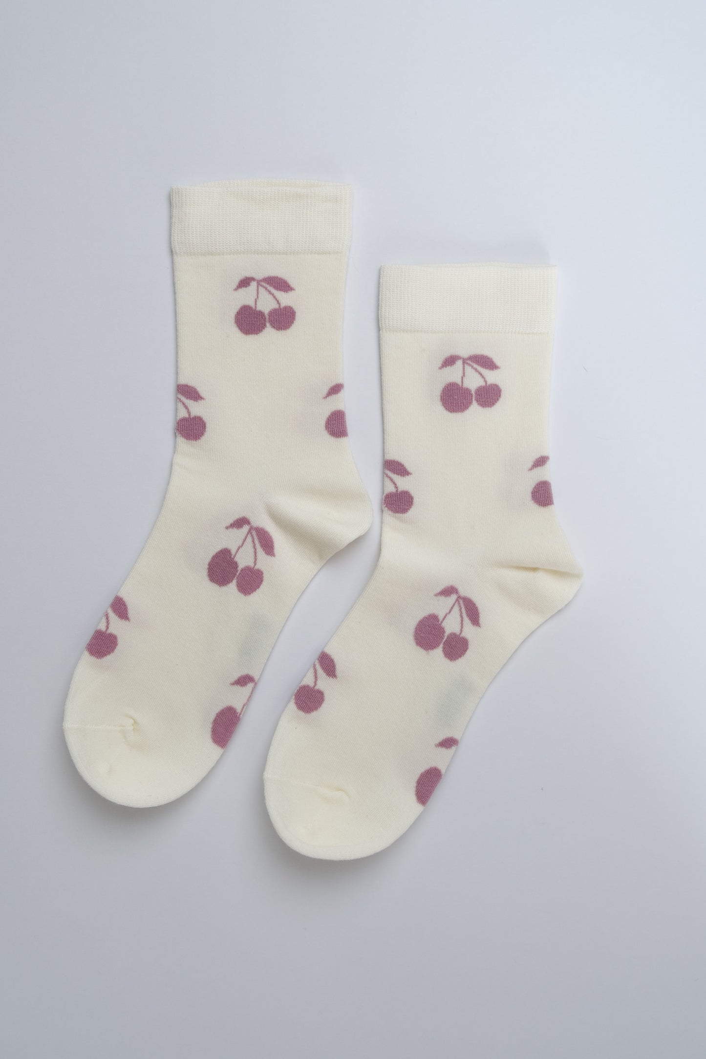 Cream-colored socks with cherry pattern on a light gray background