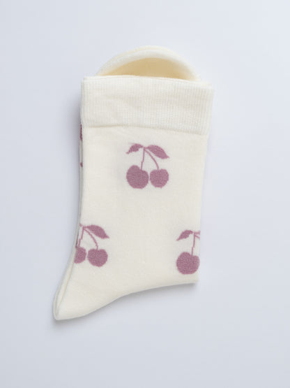 Baby bootie with cherry pattern on a light gray background