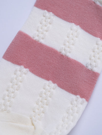 Close-up of a pink and white striped fabric with textured pattern on a white background