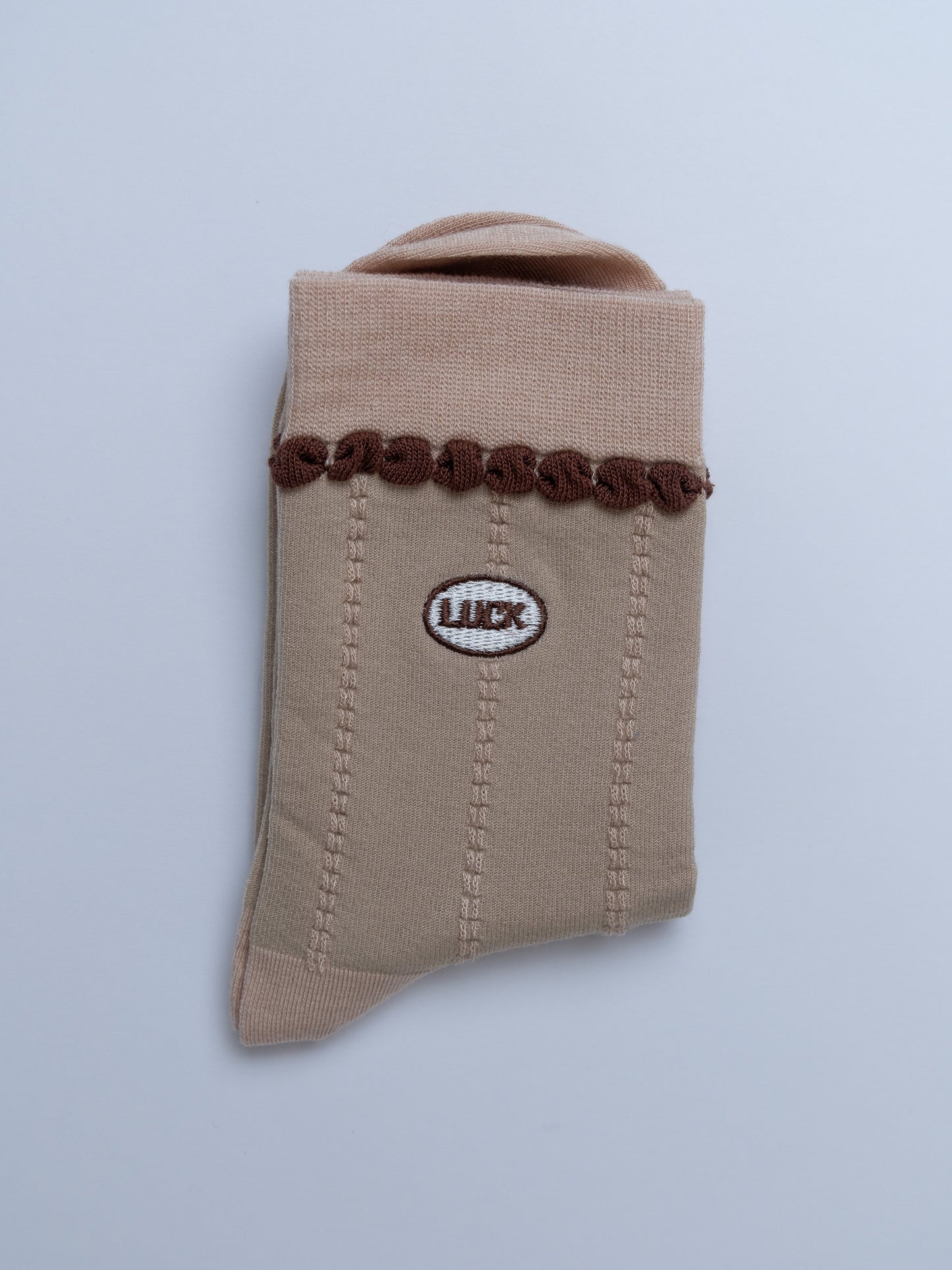 Beige fabric pouch with brown decorative elements and a logo on a light gray background