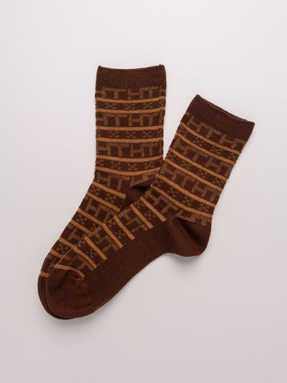 Pair of brown socks with a geometric pattern on a light gray background