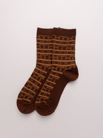 Pair of brown socks with a geometric pattern on a white background