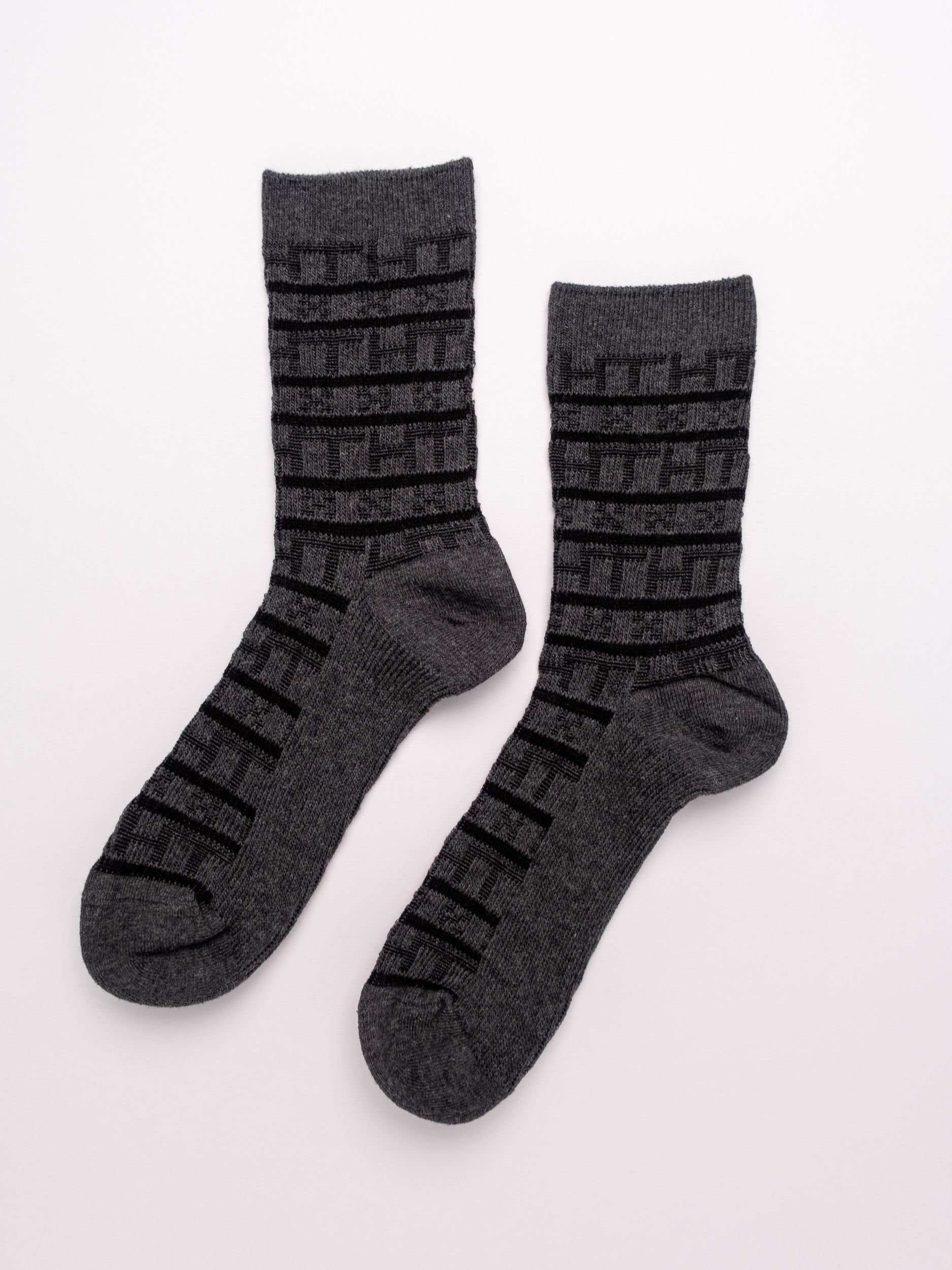 Pair of gray socks with black patterns on a white background