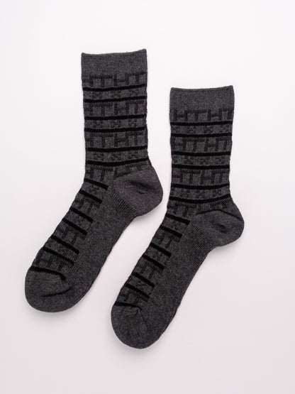 Pair of gray socks with black patterns on a white background