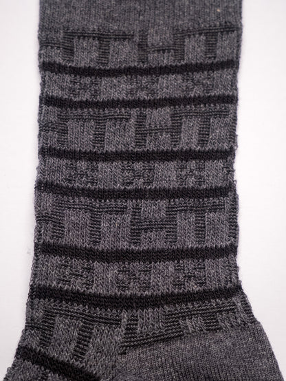 Close-up of a gray sock with black stripes on a white background