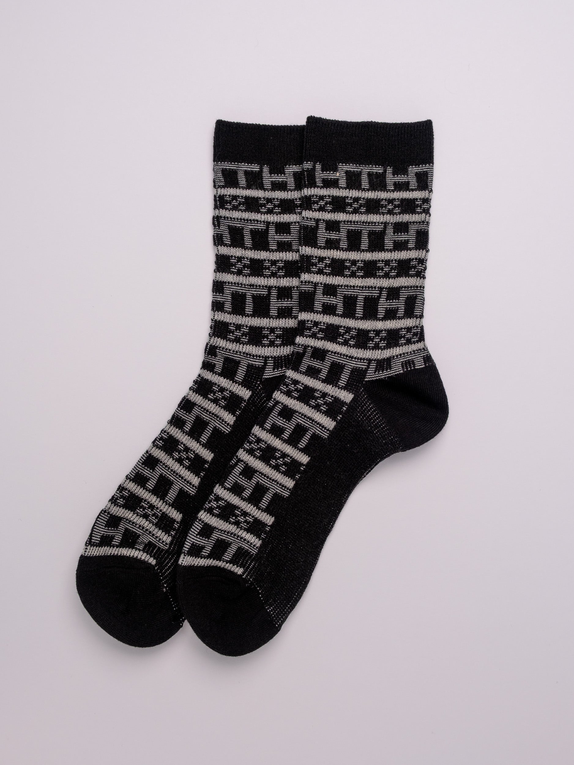 Pair of black socks with a pattern on a white background