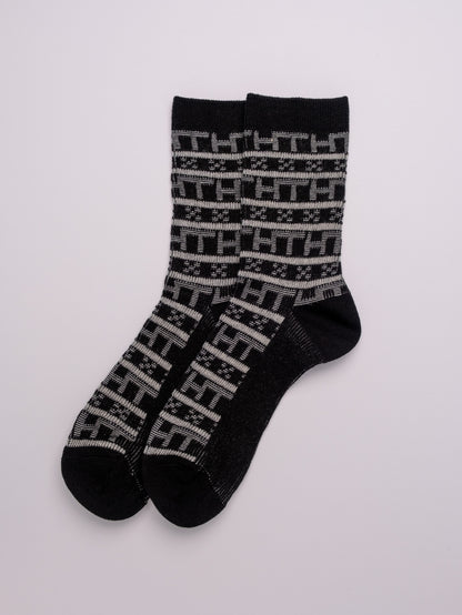Pair of black socks with a pattern on a white background