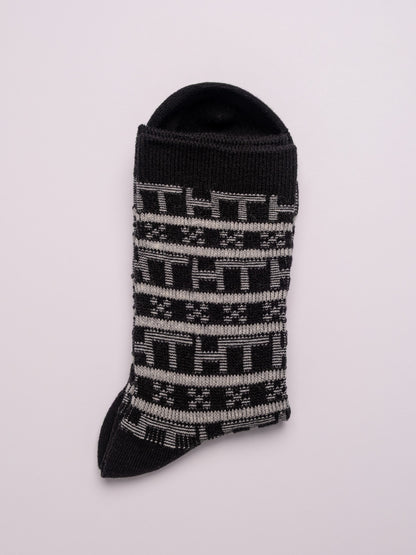 Black sock with white pattern on a light gray background