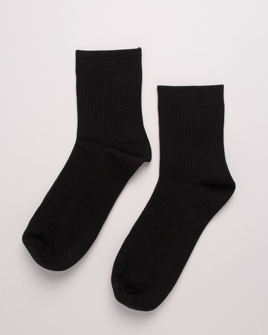 Pair of black socks on a light gray background