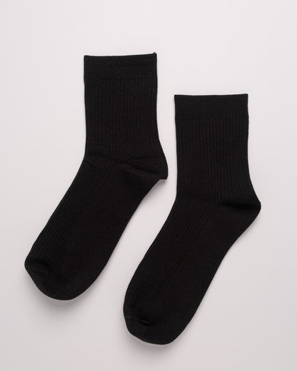 Pair of black socks on a light gray background