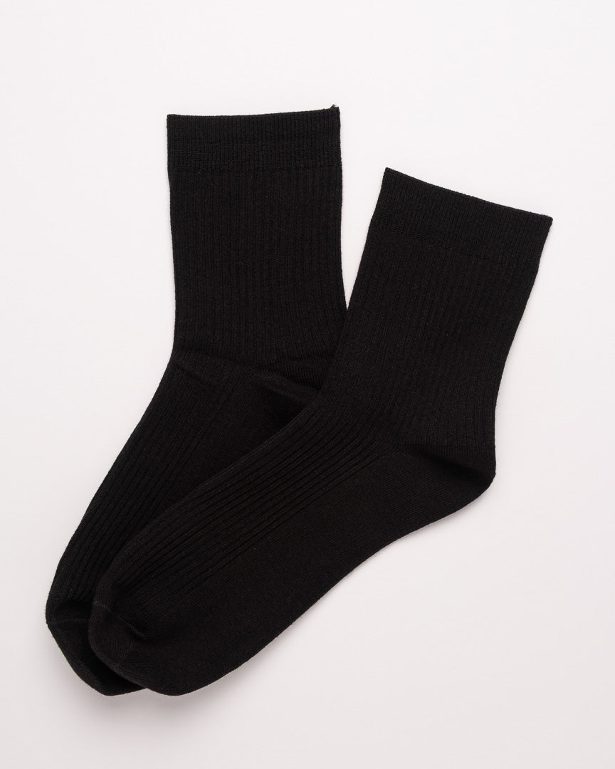 Pair of black socks on a light gray background
