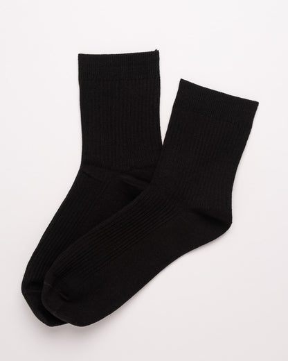 Pair of black socks on a light gray background