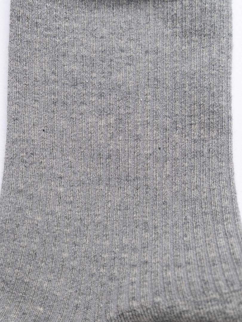 Close-up of a gray sock with visible texture on a white background