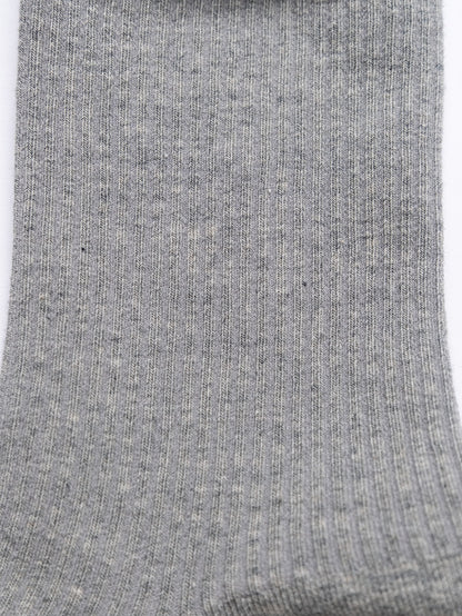 Close-up of a gray sock with visible texture on a white background