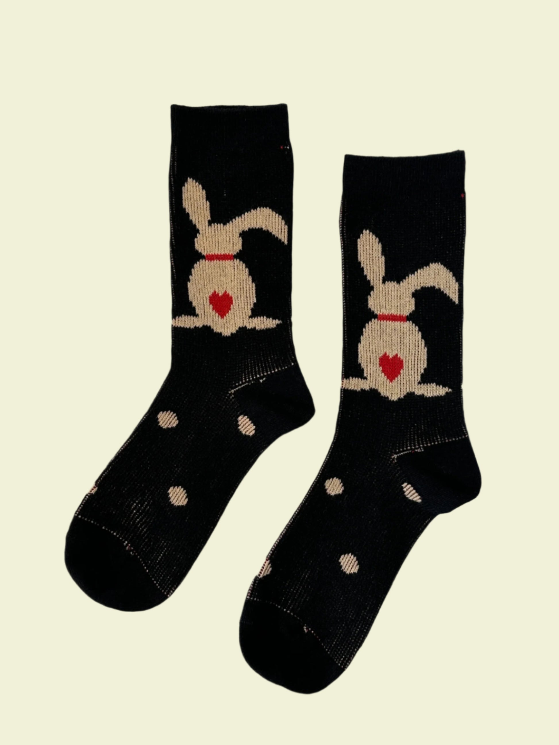 Two black socks with dog designs on a white background