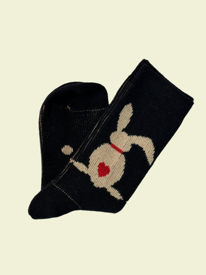 Black sock with a white dog design on a light gray background